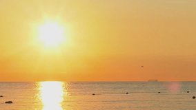 Solar path on the sea with big sunrise sun and ship on the horizon