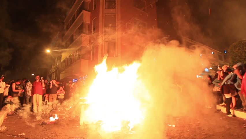 BANOS DE AGUA SANTA, ECUADOR - JANUARY 1: People throwing clothes into the fire