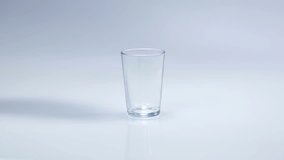 An empty glass is standing on a table in the kitchen. Someone is pouring some milk in it so that it is full. Close-up shot. - Powered by Shutterstock - Get 15% off with code: PIKWIZARD15