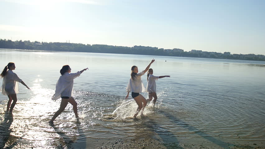 Dancing performance on water of four girls near beach