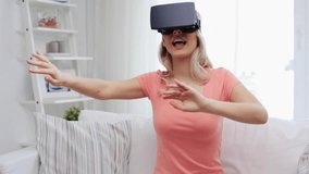 technology, cyberspace, entertainment, gaming and people concept - happy young woman with virtual reality headset or 3d glasses playing game at home