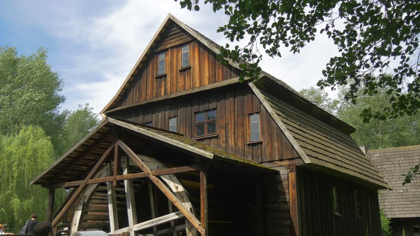 Storey Wooden Hut in the Park With Green Trees and Clear Blue Sky. Contryside Holidays. Old Construction in the Forest on a Sunny Day Surrounded by Trees in Background. Old Polish Architecture