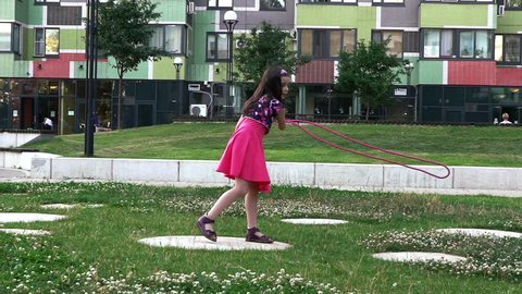 Girl playing in yard with rope 2. Slow motion.