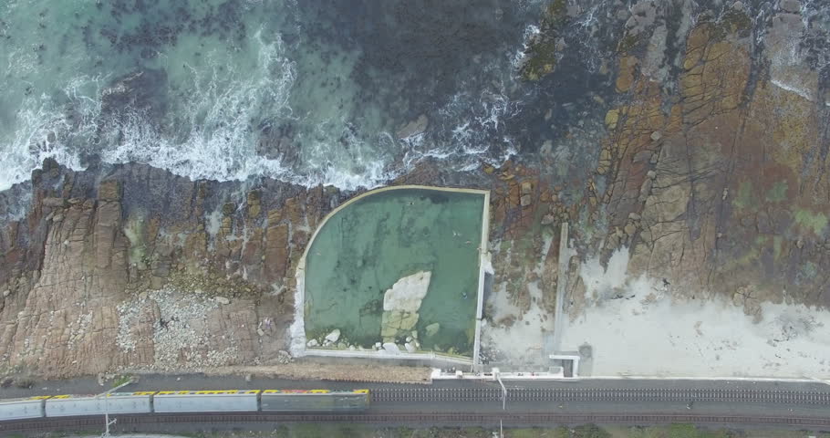 Aeriel Shot Rising Over Swimming Pool and Moving Train in Kalk Bay, Cape Town