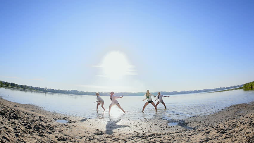 Dancing performance on water of four girls near beach