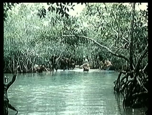 Soldiers and prisoners wading through river