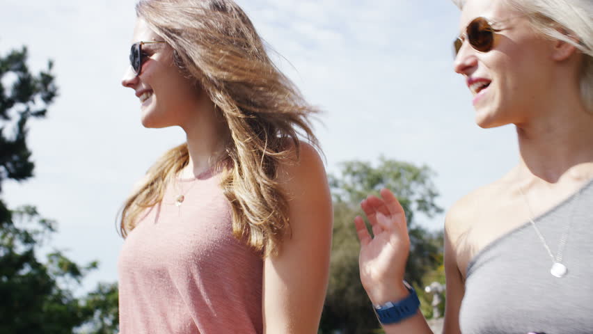 4K Young woman takes a photo of her friend on a sunny day, in slow motion 