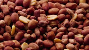 Spinning pile of roasted peanuts in dark red skins. (av29523c)