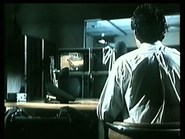 Rear view of guard watching security camera