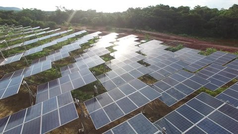 4K Aerial view of Industrial Solar Panels Farm .Drone Flight Over Field Renewable Green Alternative Energy Concept in Thailand.