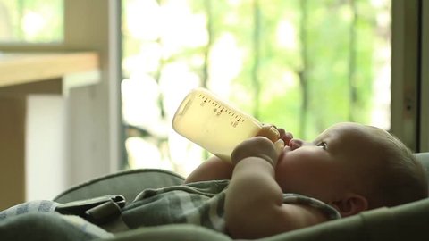 Baby eating milk from bottle