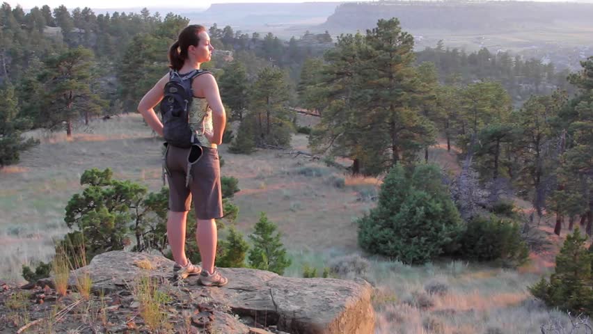 Young, fit woman on a cliff at sunset