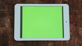  digital tablet computer with green screen on table