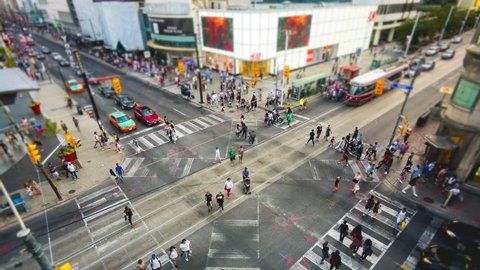 Toronto, Canada - June 26, 2016: Time lapse view of people and traffic crossing busy intersection at Yonge-Dundas Square in Toronto, Ontario, Canada.