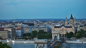 Evening view to Chain bridge, famous landmark on the Danube river in Budapest city, Hungary. Europe. Old buildings and Opera hungarian theatre on the banks. Panorama from hill top view. Full-hd video.