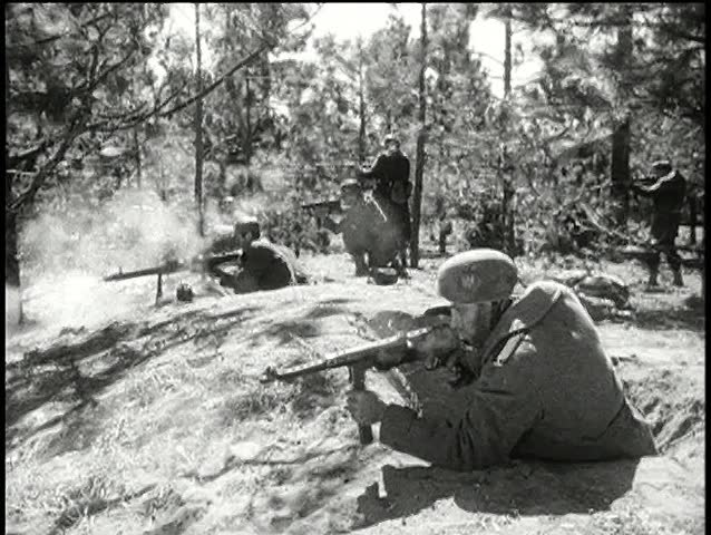 Side view soldiers in forest firing machine guns