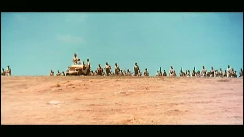 Wide shot line of soldiers appearing over hill