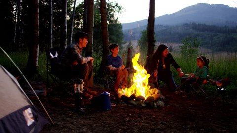 Happy American Caucasian family camping in forest on holiday outdoors