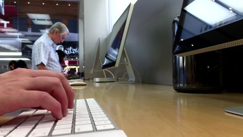 Coquitlam, BC, Canada - July 25, 2016 : Woman sending message for her friend inside Apple store with 4k resolution.