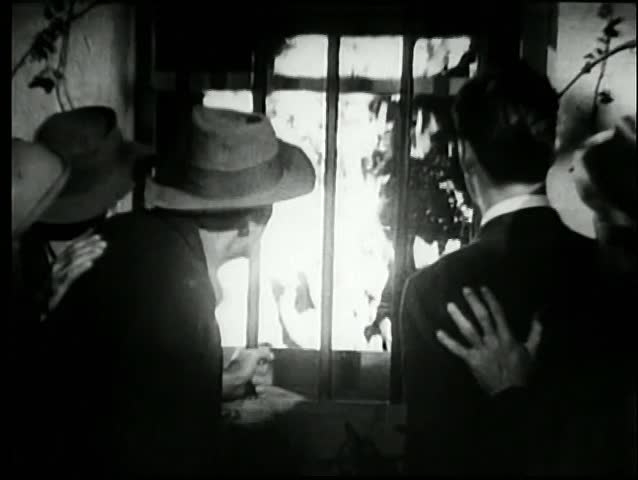 People watching blazing fire through window