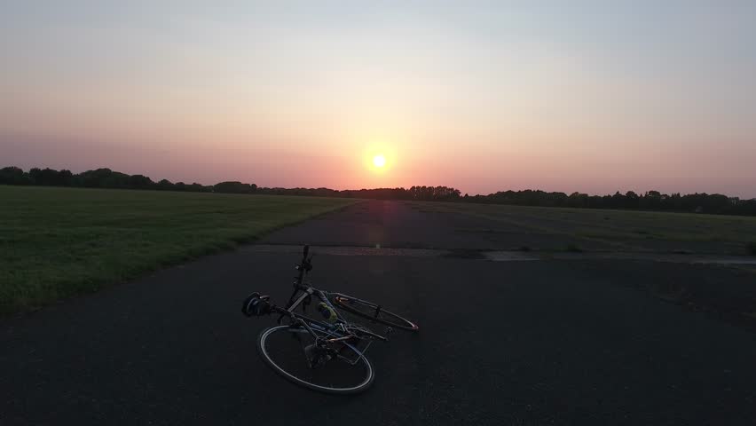 Rise into sunset from bike across an airfield