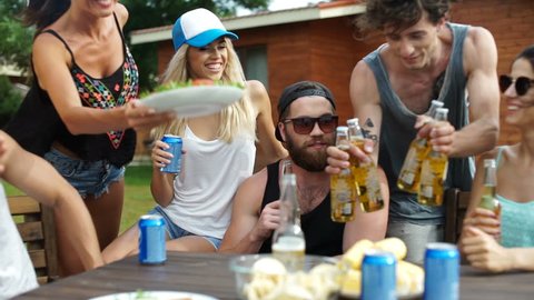 Group of young beautiful happy teenagers drinking beer at the picnic area