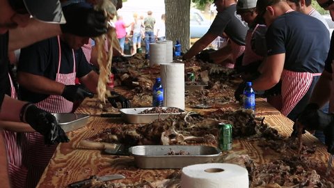 FOUNTAIN GREEN, UTAH - JUL 2016: Meat cutting cooked lamb for town celebration lunch. Annual rural community celebration. Sheep industry. BBQ pit cooking of lambs making of thousands of sandwiches.