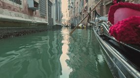 VENICE, ITALY - JUNE 19, 2016: Riding on gondola on a narrow canals of Venice, Italy