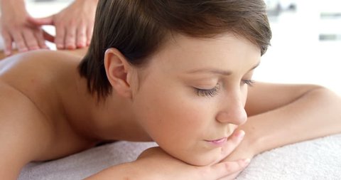 Side view of woman therapist massaging the back of her patient in a medical office