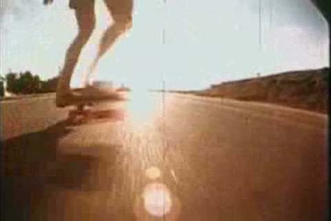 Skateboarders jump over a camera and a single board is showcased in 1976. (1970s)