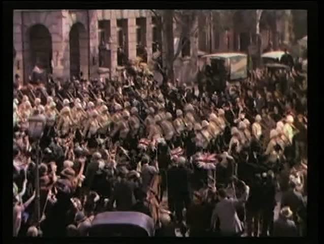 Wide shot British Army marching through street