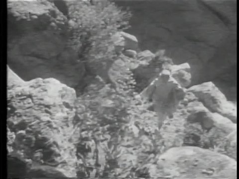 Moroccan boy climbing up mountain and signaling soldiers