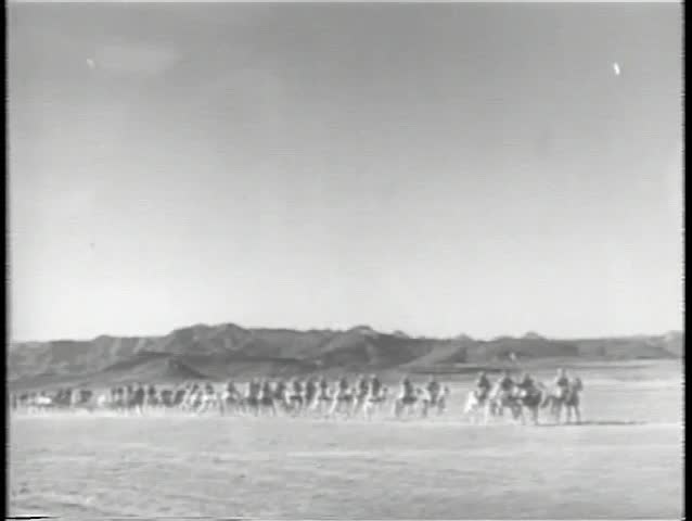 Soldiers on horseback traveling through the desert