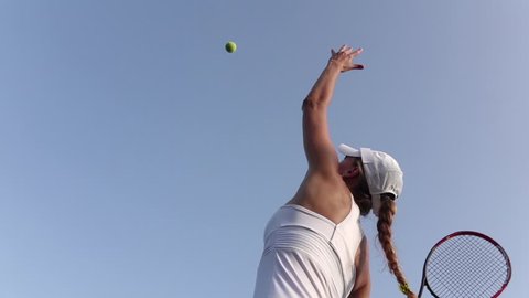 Girl serving tennis ball. Tennis player. Slow motion