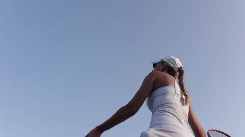 Beautiful female tennis player serving outdoor