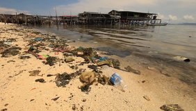Plastic pollution in ocean washes up onto tropical island beach