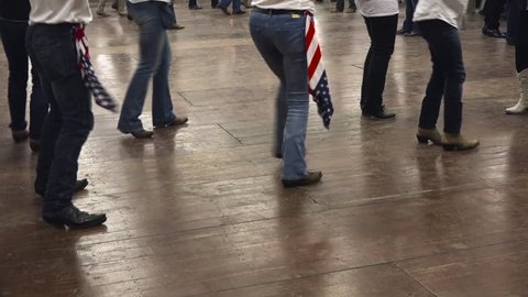 Western dancers dancing a choreography at a country festival, wearing cowboy boots, jeans and USA flag. Learning line dance. Music, traditions and fun