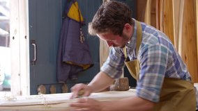 Man Shaping Custom Surfboard In Workshop Shot On RED Camera - Powered by Shutterstock - Get 15% off with code: PIKWIZARD15