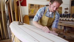 Man Shaping Custom Surfboard In Workshop Shot On RED Camera - Powered by Shutterstock - Get 15% off with code: PIKWIZARD15