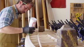 Man Glueing Custom Surfboard In Workshop Shot On RED Camera - Powered by Shutterstock - Get 15% off with code: PIKWIZARD15