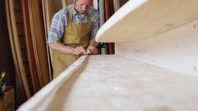 Man Shaping Custom Surfboard In Workshop Shot On RED Camera - Powered by Shutterstock - Get 15% off with code: PIKWIZARD15