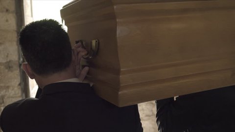 Pallbearers leaving Church with coffin followed by family