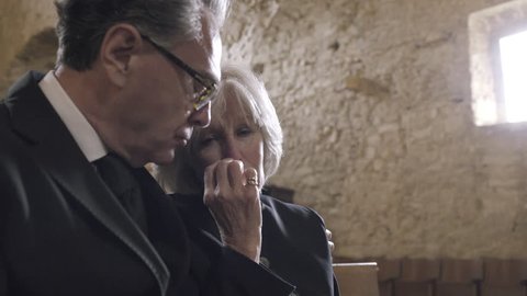 Grandmother crying at a funeral with granddaughter