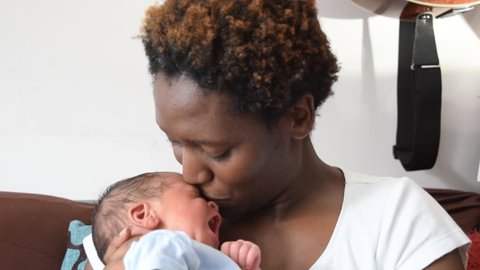 Black African Motherbreast feeds her mixed race infant Hertfordshire, England United Kingdom