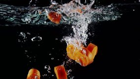 Slow motion chopped carrot falls into water with splashes on black background cooking vegetables - Powered by Shutterstock - Get 15% off with code: PIKWIZARD15