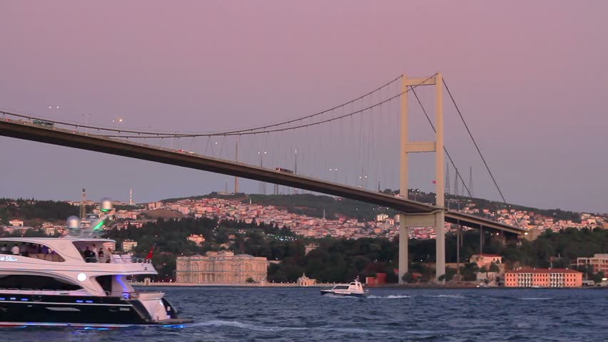 Luxury yacht sails under Bosporus Bridge in Istanbul 