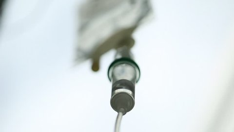 Extreme close up of intravenous iv drip slowly dripping away. Shot using a macro lens the depth of field is nice and shallow and every detail is very clear.