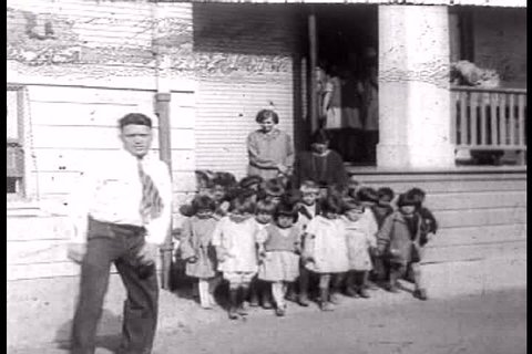 A continual stream of young children on up flood out of a schoolhouse\xCDs doors, Martinez, California in 1927. (1920s)