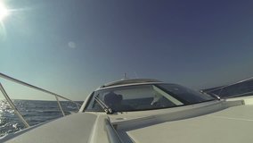 visible deck yacht, bright sun shines, captain's cabin, White high-speed motor yacht floating in the sea, video