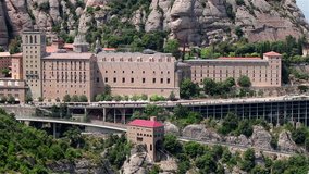 Timelapse of the general view of the Montserrat monastery with a train and pedestrians